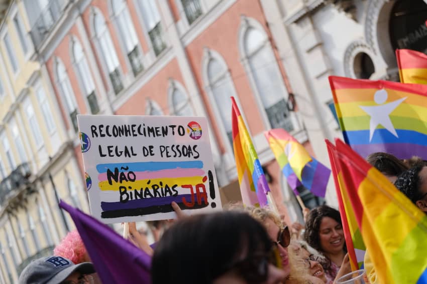 Marcha del Orgullo en Lisboa con un cartel que pone "reconocimiento legal del género no binario, YA"