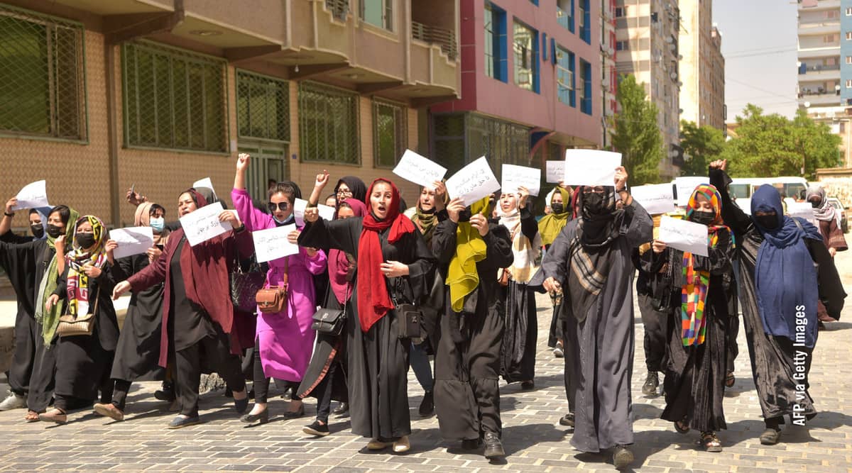 Mujeres afganas sostienen pancartas mientras marchan para protestar por sus derechos